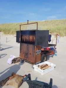 Paling die gerookt wordt in een rookkar op het strand